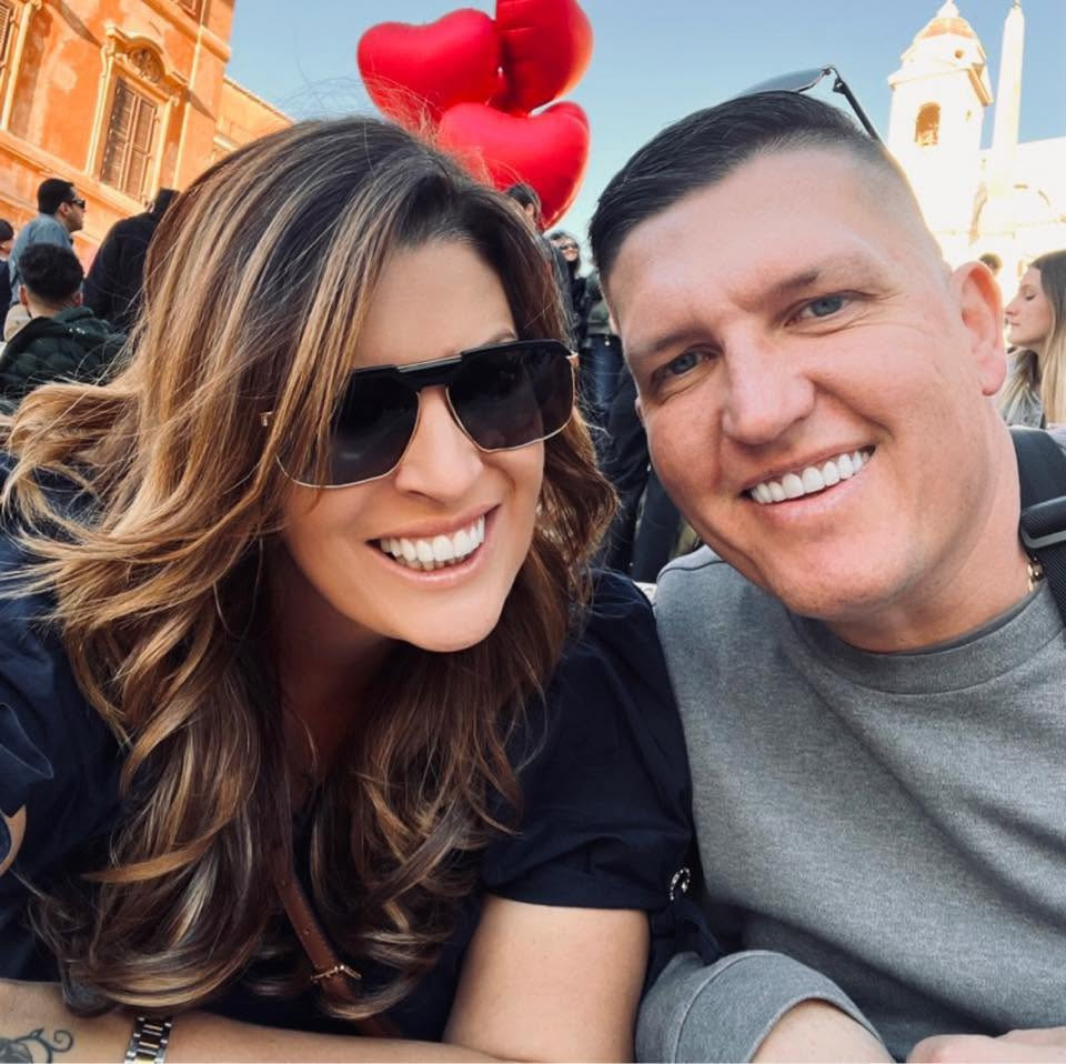 Katie and Matt smiling together on a sunny city break